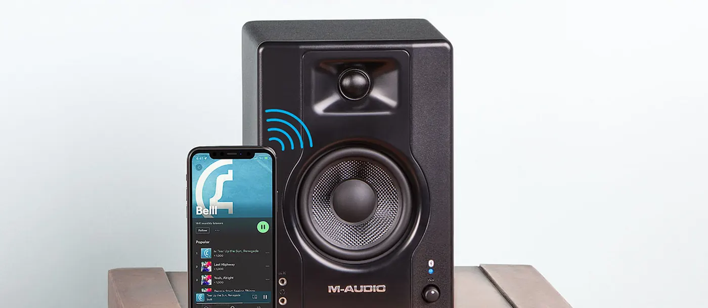 Enceinte BX3 BT sur un meuble en bois avec un smartphone qui diffuse de la musique en Bluetooth
