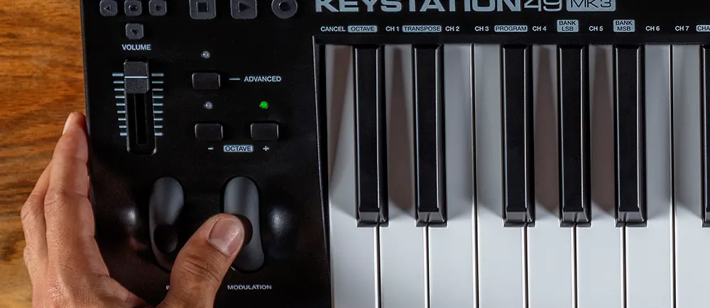 Main sur la molette de modulation du Keystation 49 MK3, avec le fader de volume et les boutons d'octave au-dessus