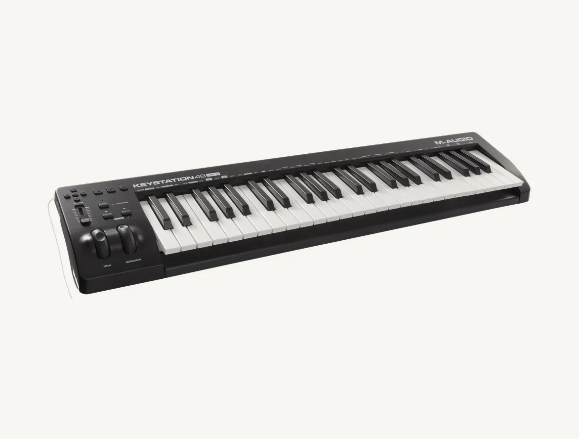 Clavier maître M-Audio Keystation 49 MK3 vu de trois quarts, 49 touches, molettes et fader à gauche