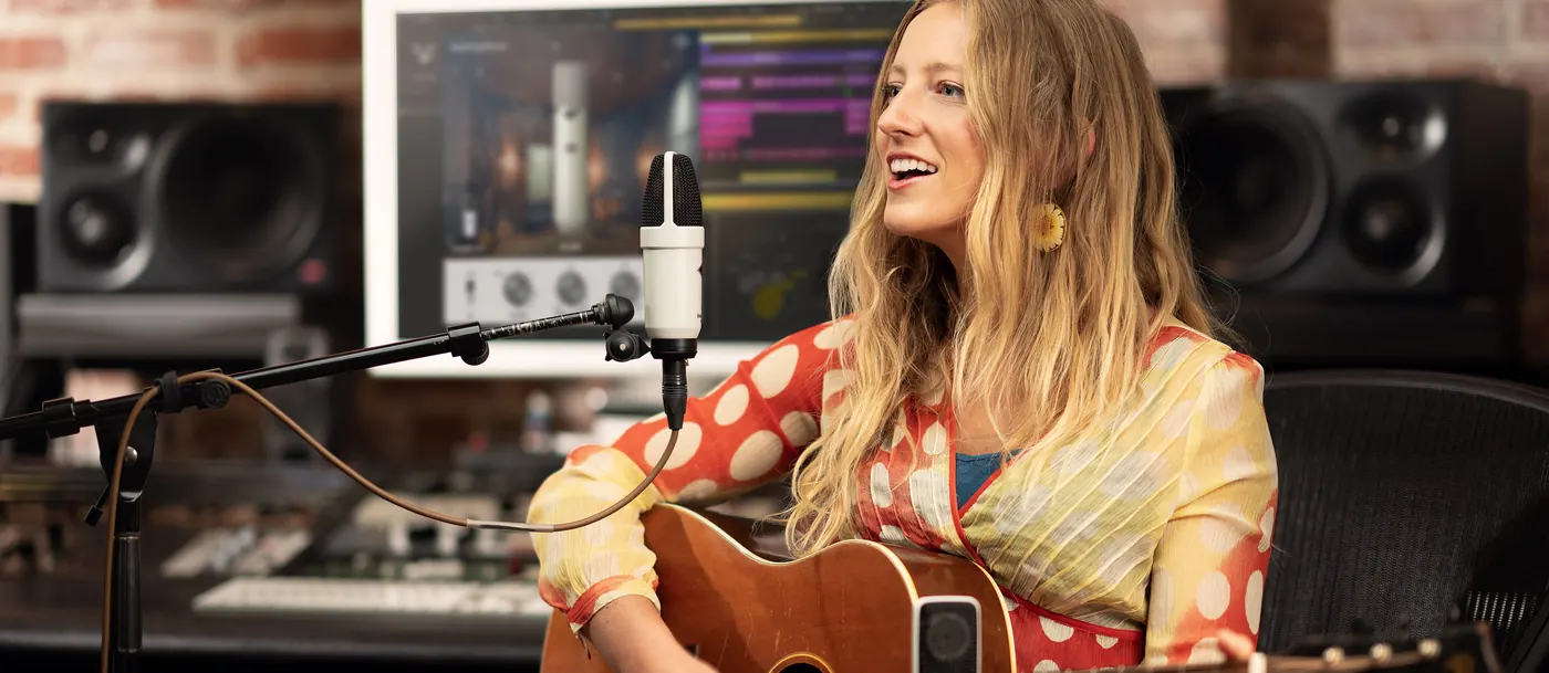 Chanteuse guitariste en studio devant un micro SC-1 monté sur pied
