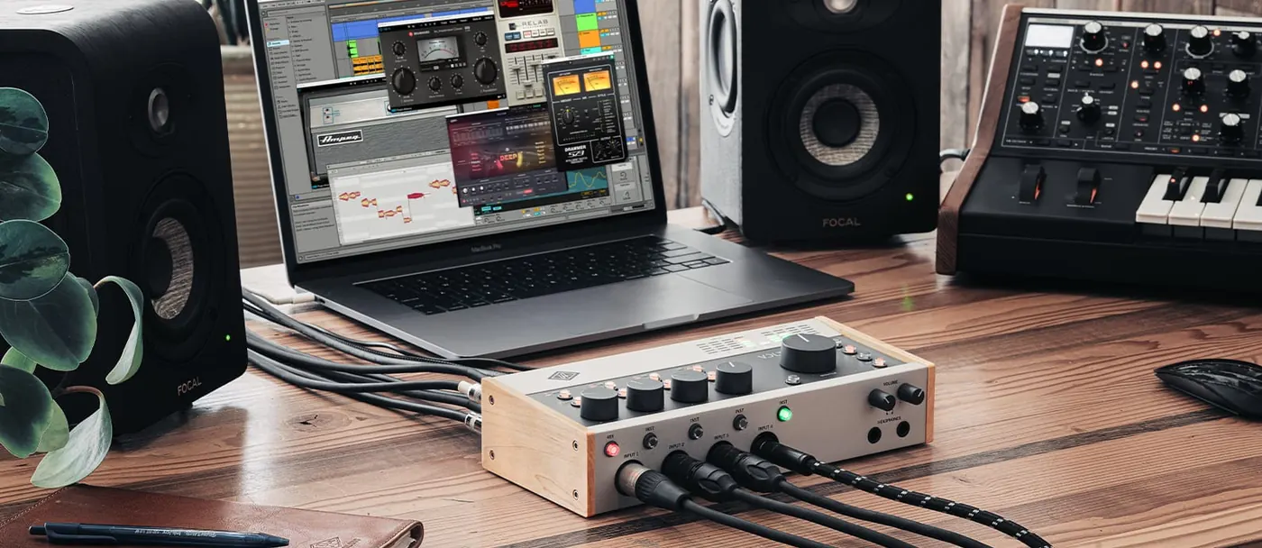 Volt 476P sur un bureau en bois devant un ordinateur portable, deux enceintes et un synthétiseur