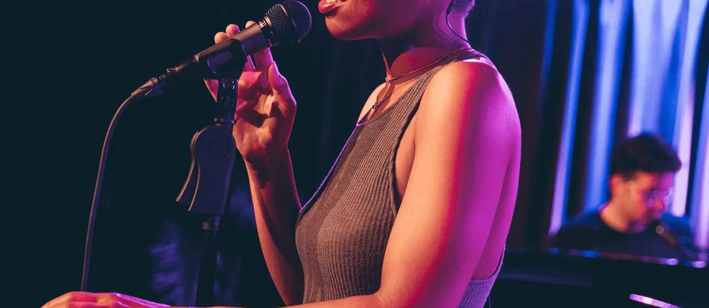 Chanteuse sur scène devant un micro sur pied