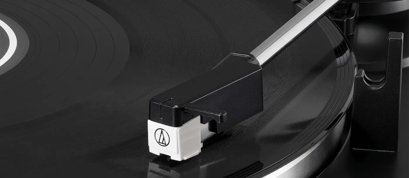 Bras de lecture et cellule blanche de l'AT-LP60X posés sur un disque vinyle en lecture