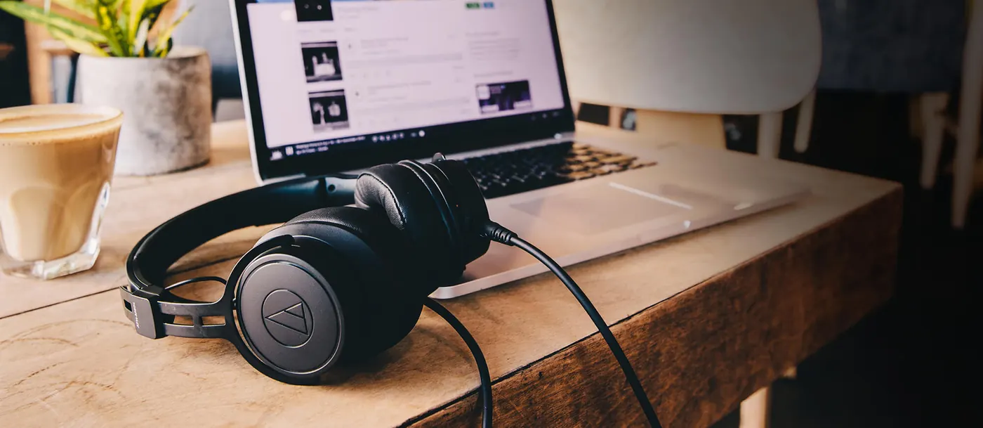 Casque ATH-M60xa posé sur un bureau en bois devant un ordinateur portable