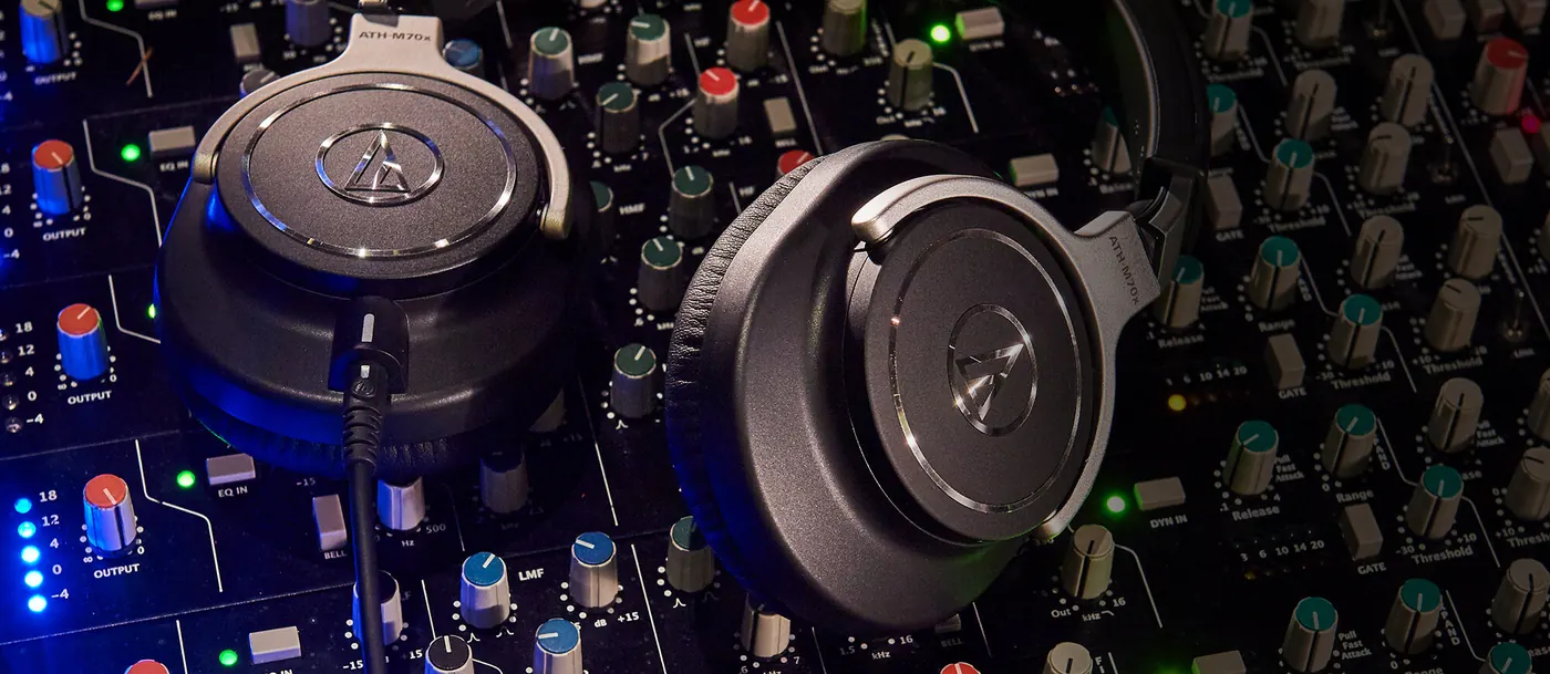 Casque ATH-M70x posé sur une table de mixage DJ aux voyants bleus