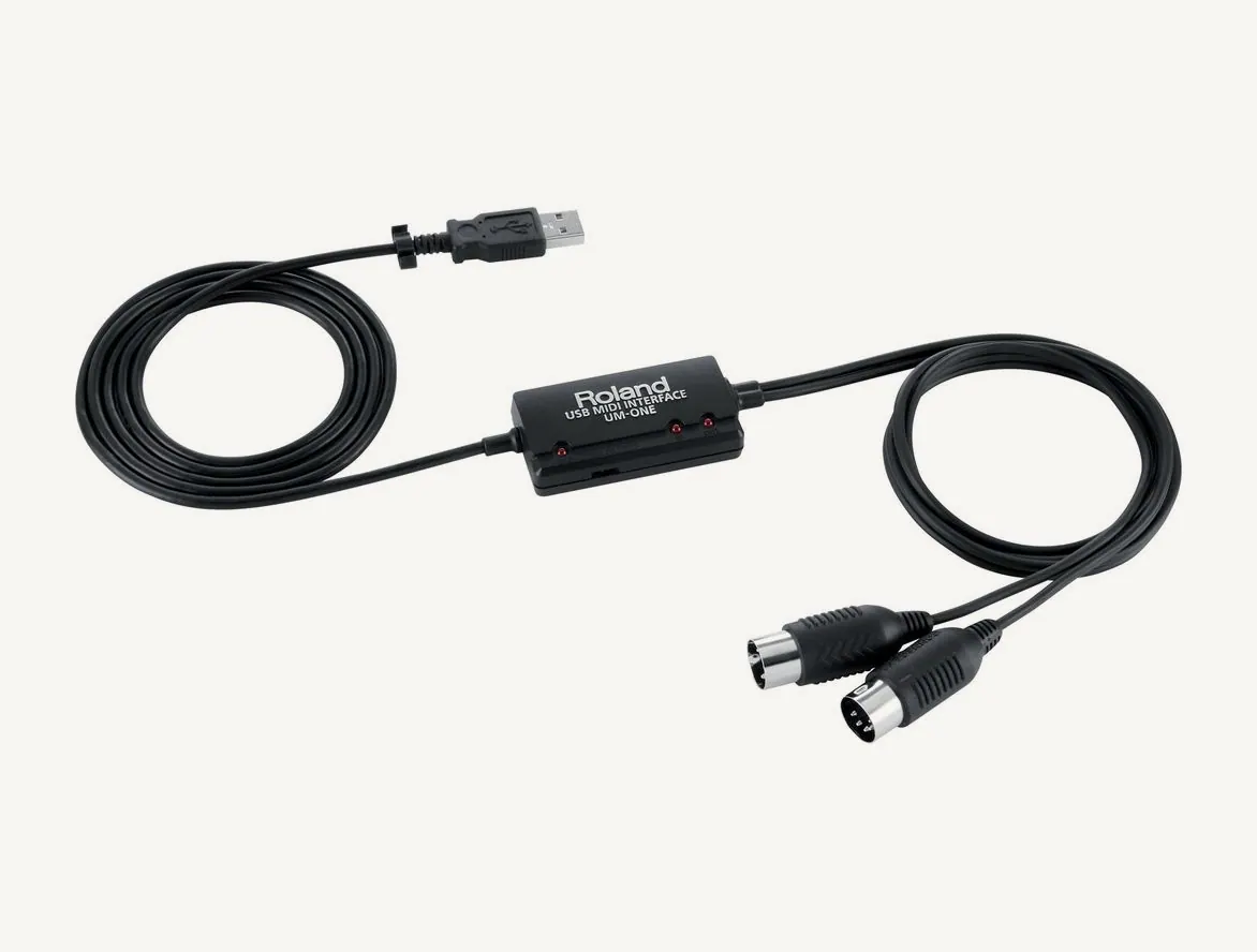 Interface MIDI USB Roland UM-ONE mk2 : câble USB, boîtier central à témoins et deux fiches MIDI
