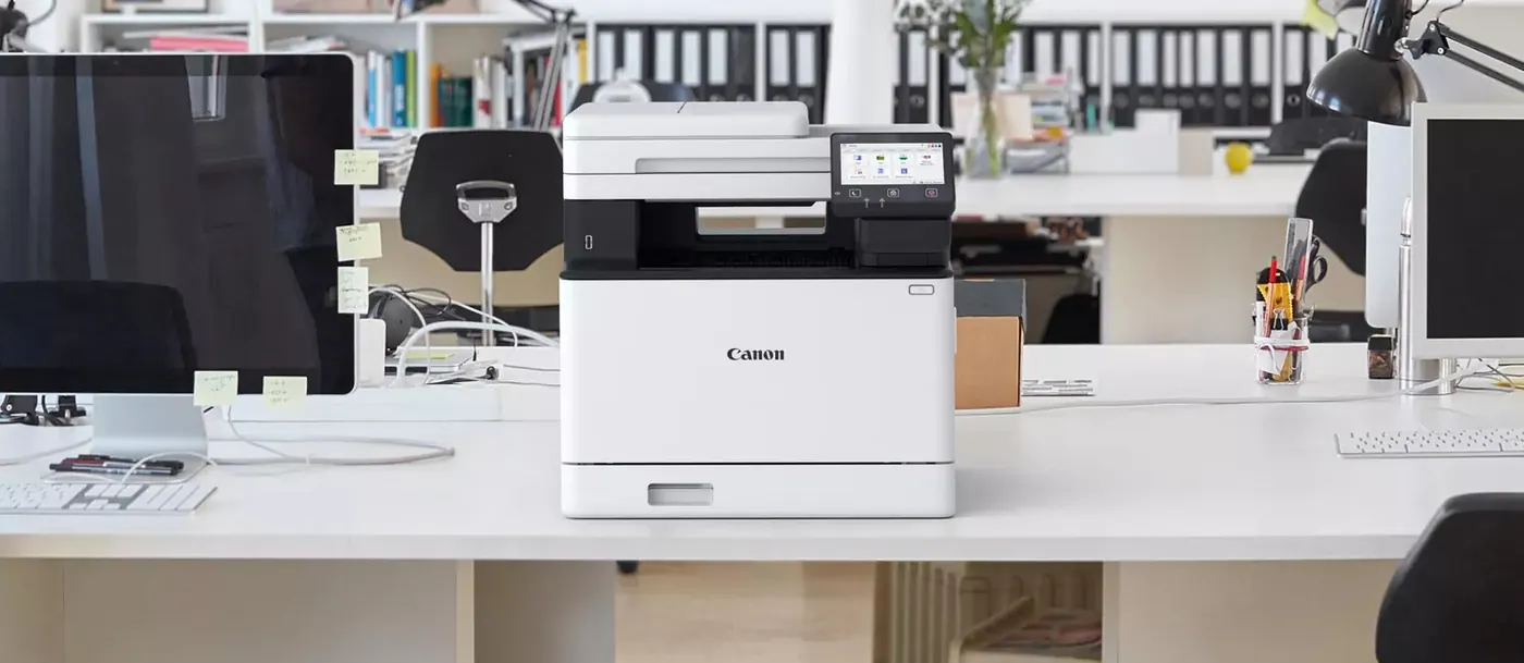 Canon i-SENSYS MF752Cdw II posée sur un bureau partagé entre deux postes de travail