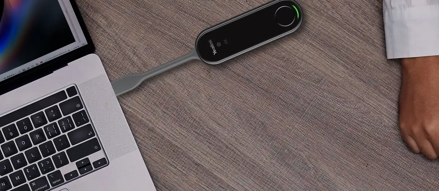 Yealink PA20 branché sur un ordinateur portable posé sur une table en bois