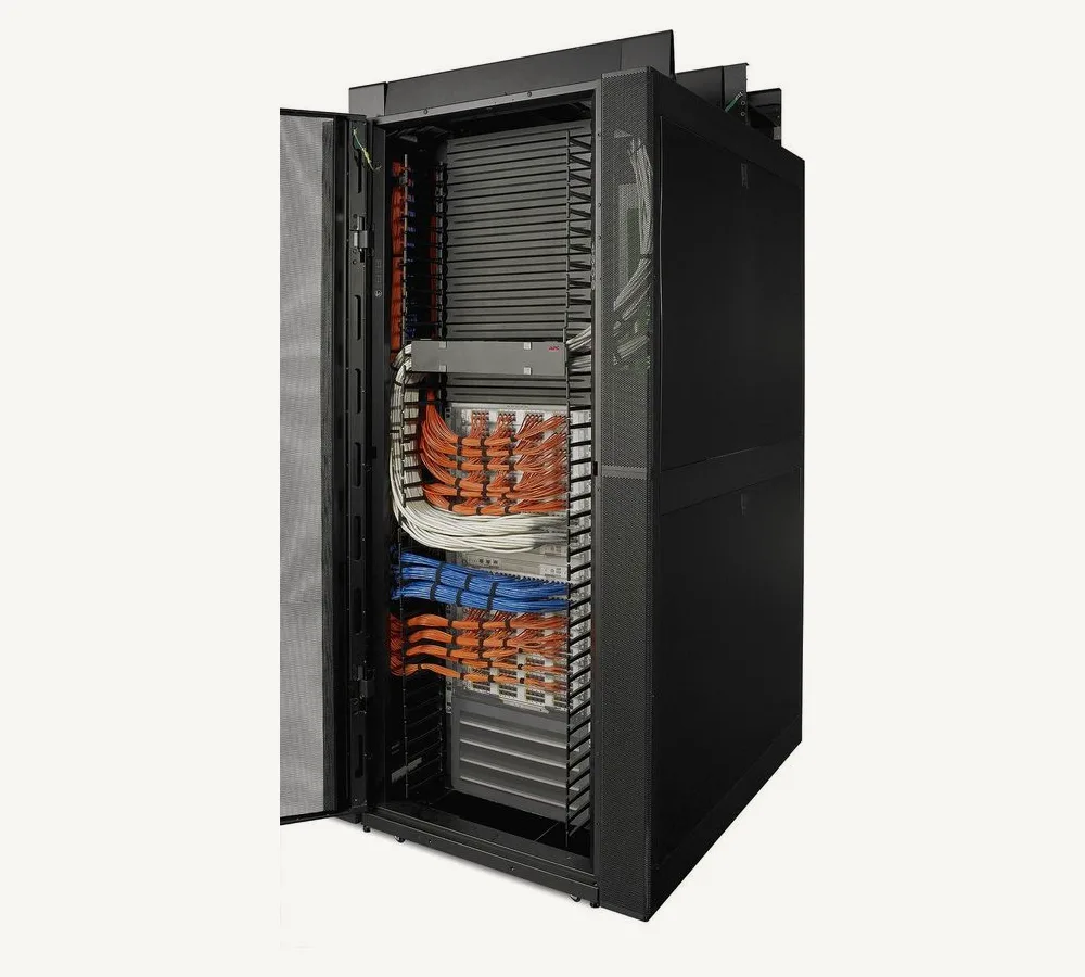 Armoire APC NetShelter SX ouverte, cordons de brassage orange, bleus et blancs rangés dans les guide-câbles verticaux