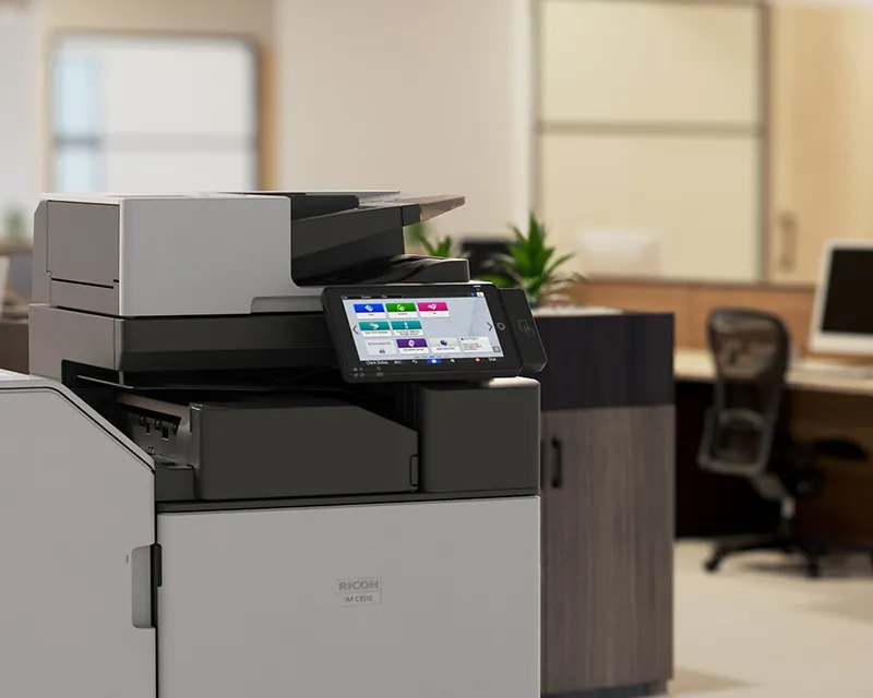 Multifonction Ricoh IM C3010 dans un open space, chargeur de documents SPDF sur le dessus et écran tactile allumé